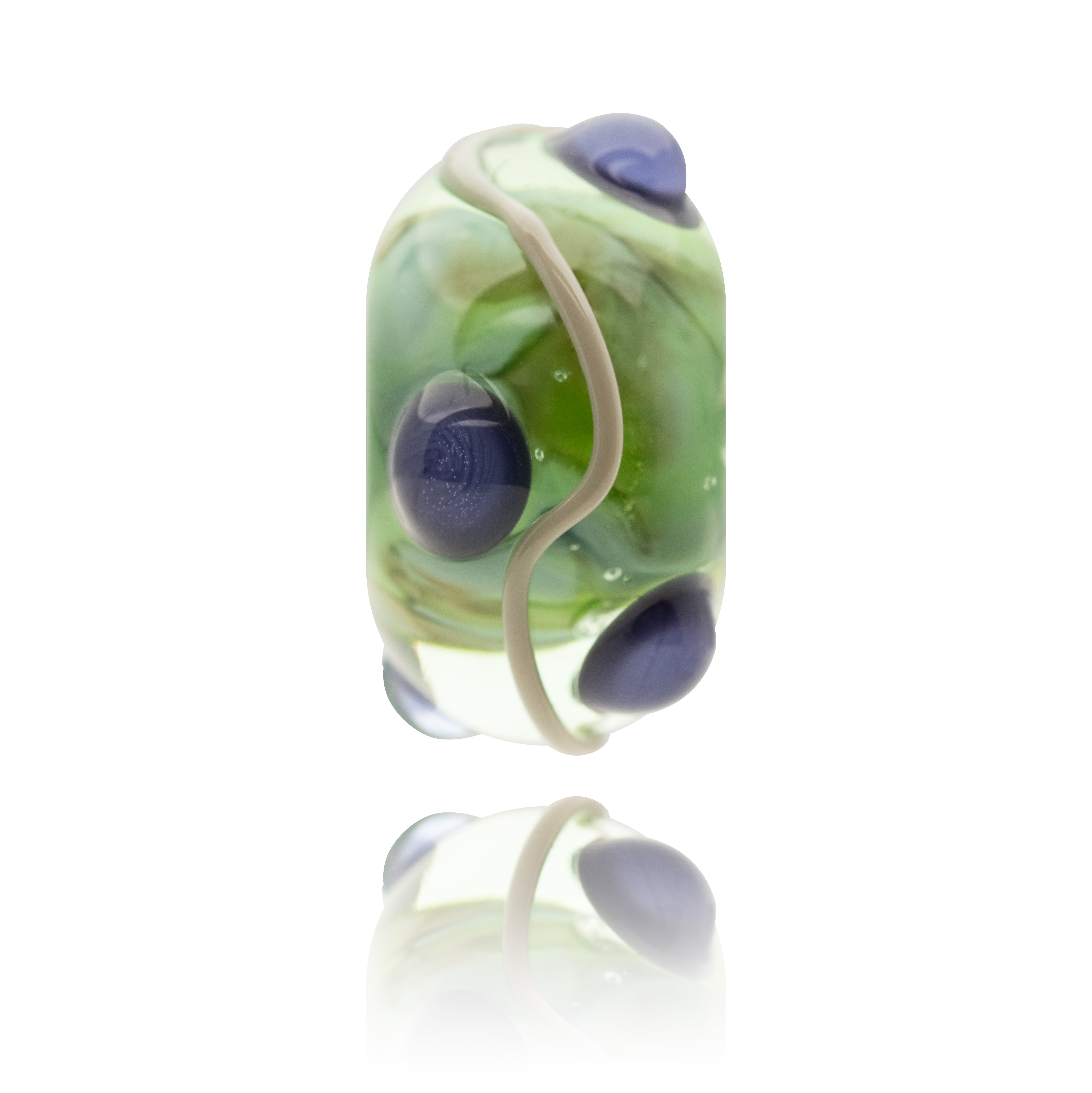 Decorative glass bead with green and blue swirls on a white background