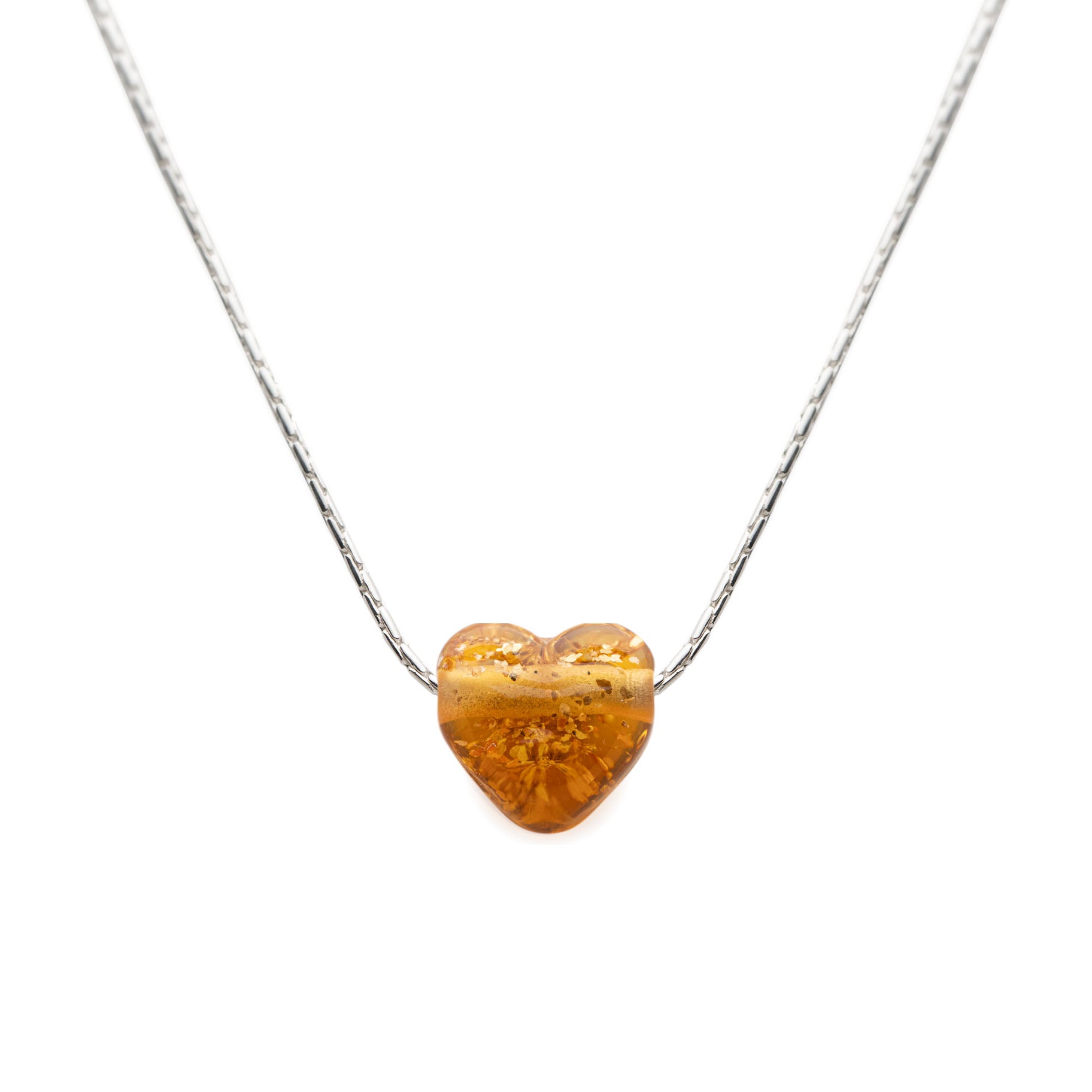 Heart-shaped amber pendant on a silver chain against a white background