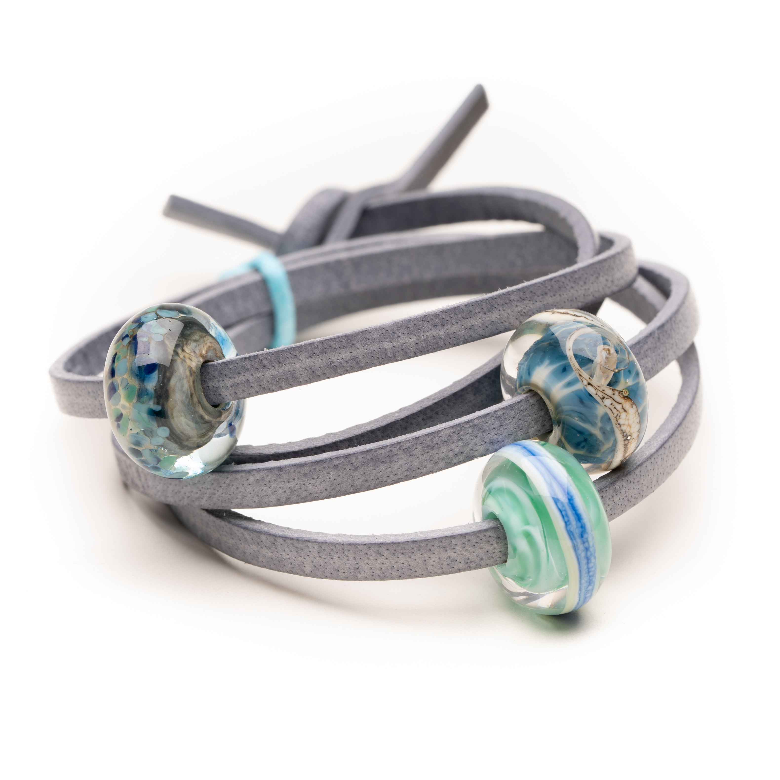 Grey leather bracelet with glass beads in green, blues and clear for Northumberlands best beaches.