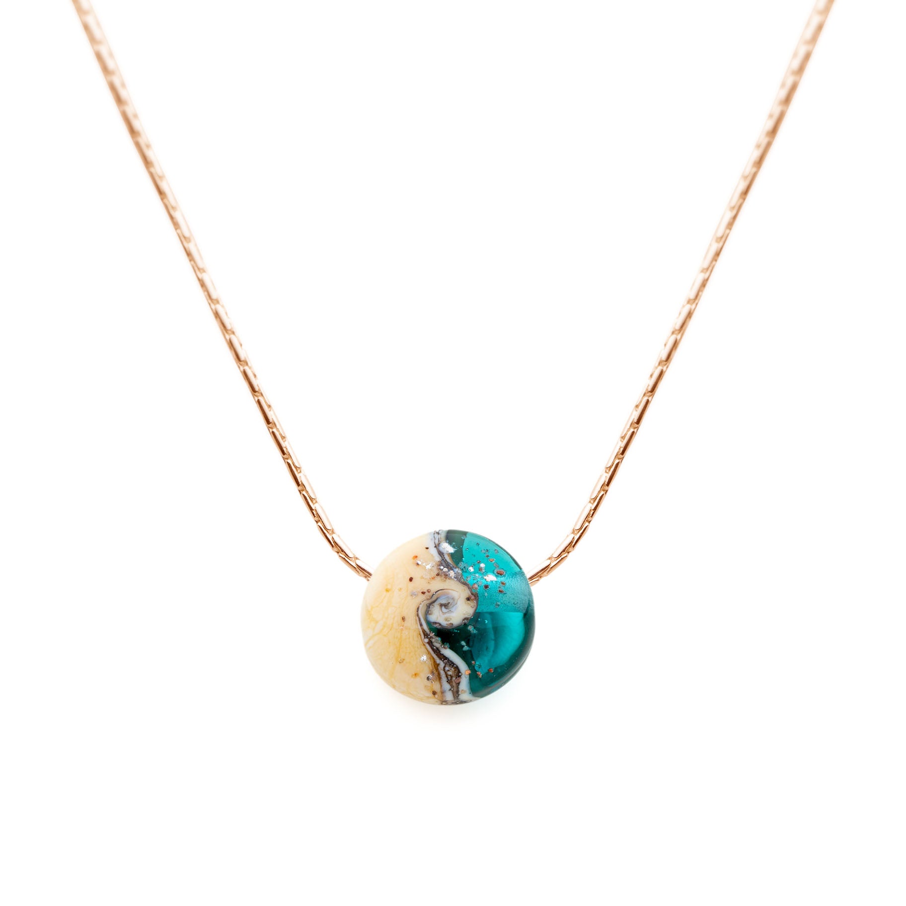 Shoreline inspired glass bead in teal and sand coloured glass with your chosen beach sand pressed onto the surface strung on a gold chain necklace.