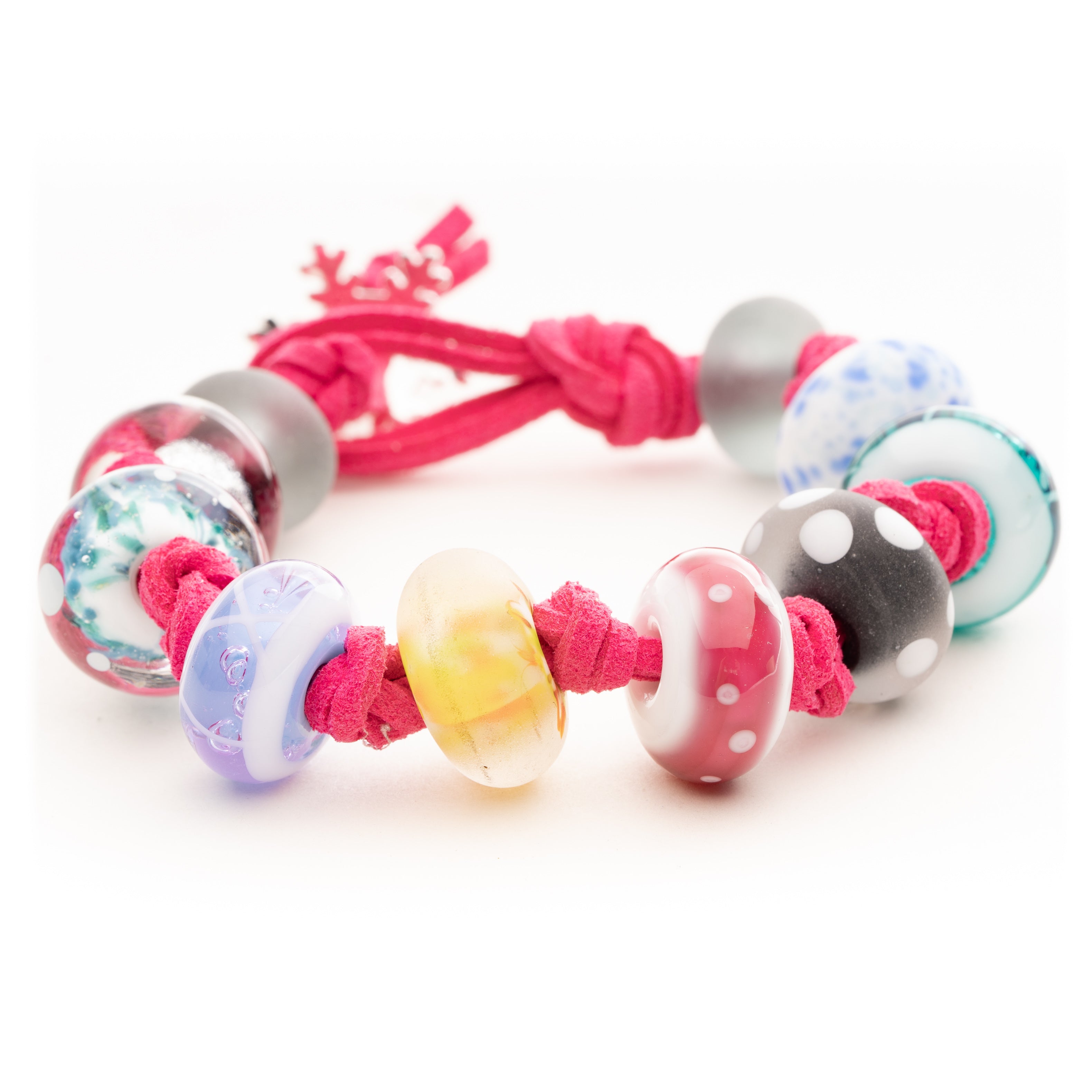 Bright pink cord bracelet with colorful glass beads inspired by snow resorts from around the world.