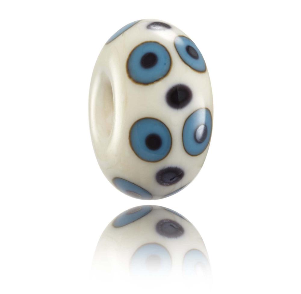 Cream glass bead with purple and blue dots on the surface, design for Lacanau in France.