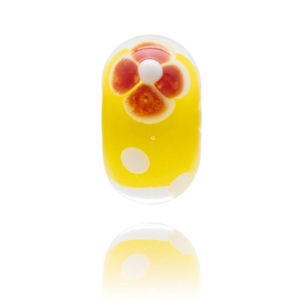 Yellow glass bead with a red flower on the surface, sold to raise funds for the Cystic Fibrosis Trust in the UK.