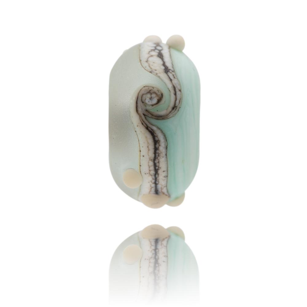 Green and clear frosted glass bead with a brown mottled swirl around the middle and little white surface dots, representing Lulworth Cove in Dorset.