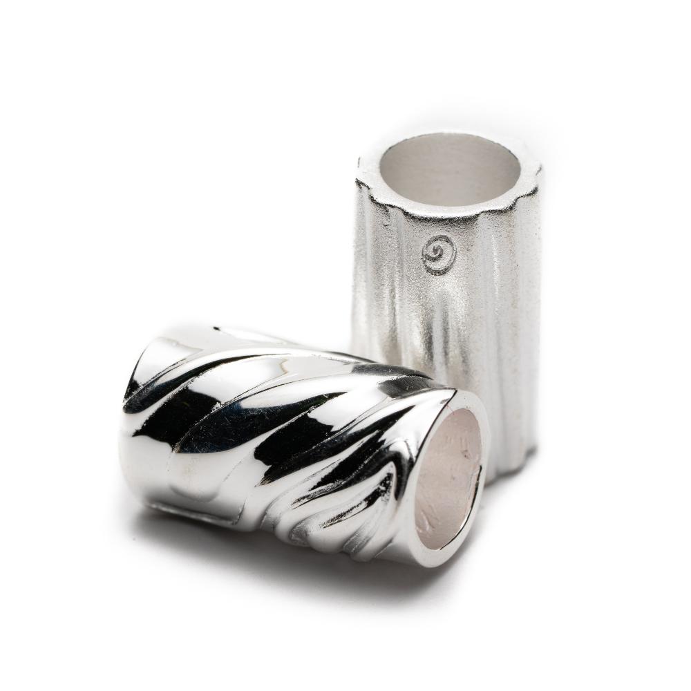 Silver tube shaped beads with engraving on the outside.