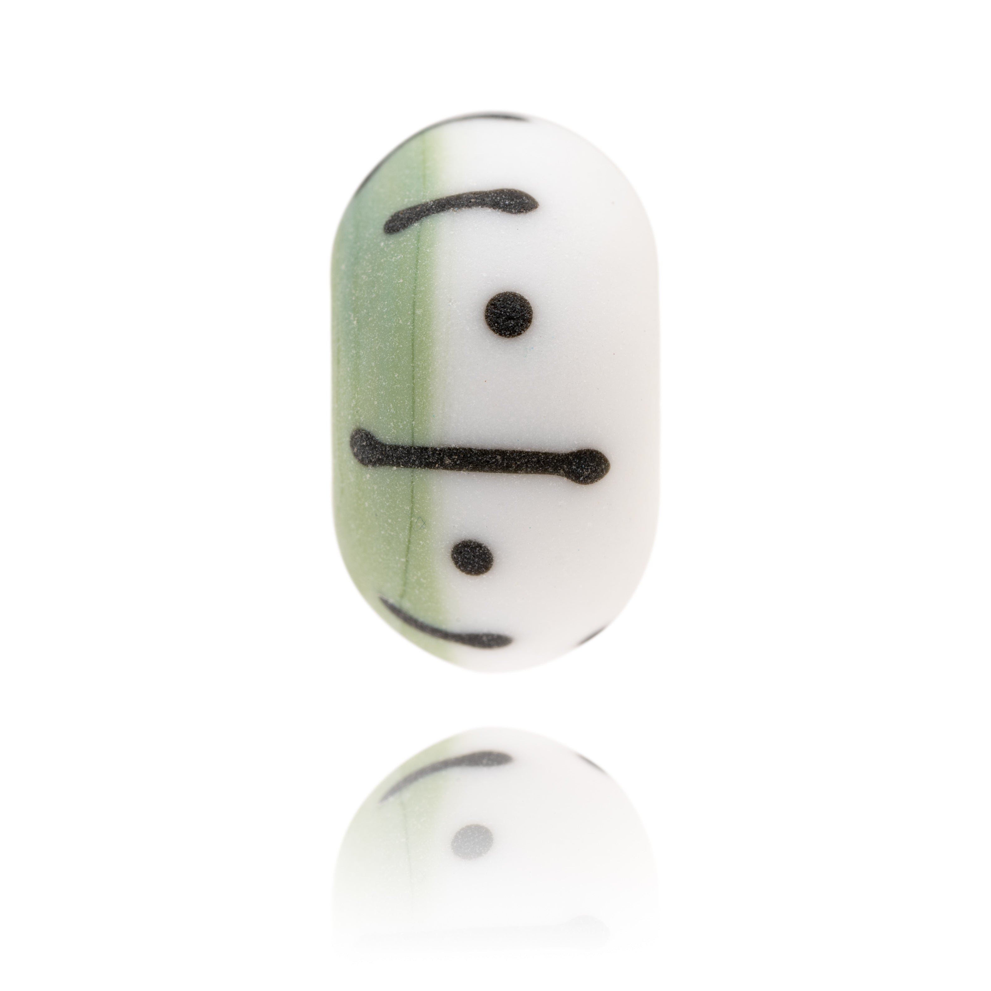 Green and white Murano glass bead decorated with black dots and stripes, representing Eastbourne Beach in Sussex.