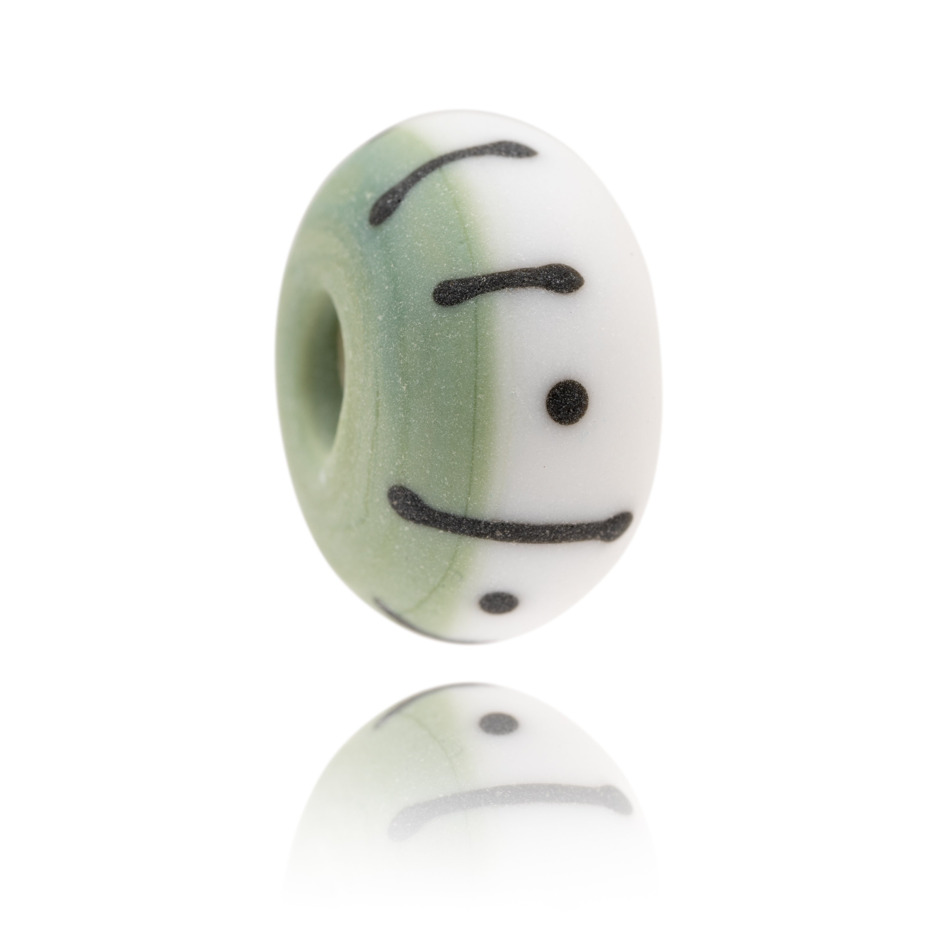 Green and white Murano glass bead decorated with black dots and stripes, representing Eastbourne Beach in Sussex.