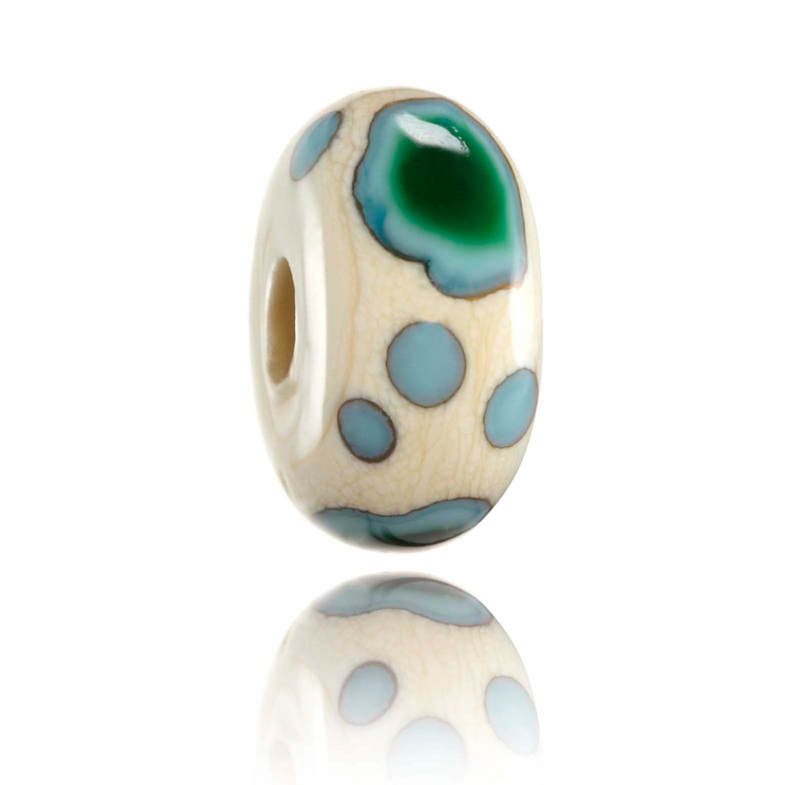 Cream glass bead with green dots representing the Fijian Islands.
