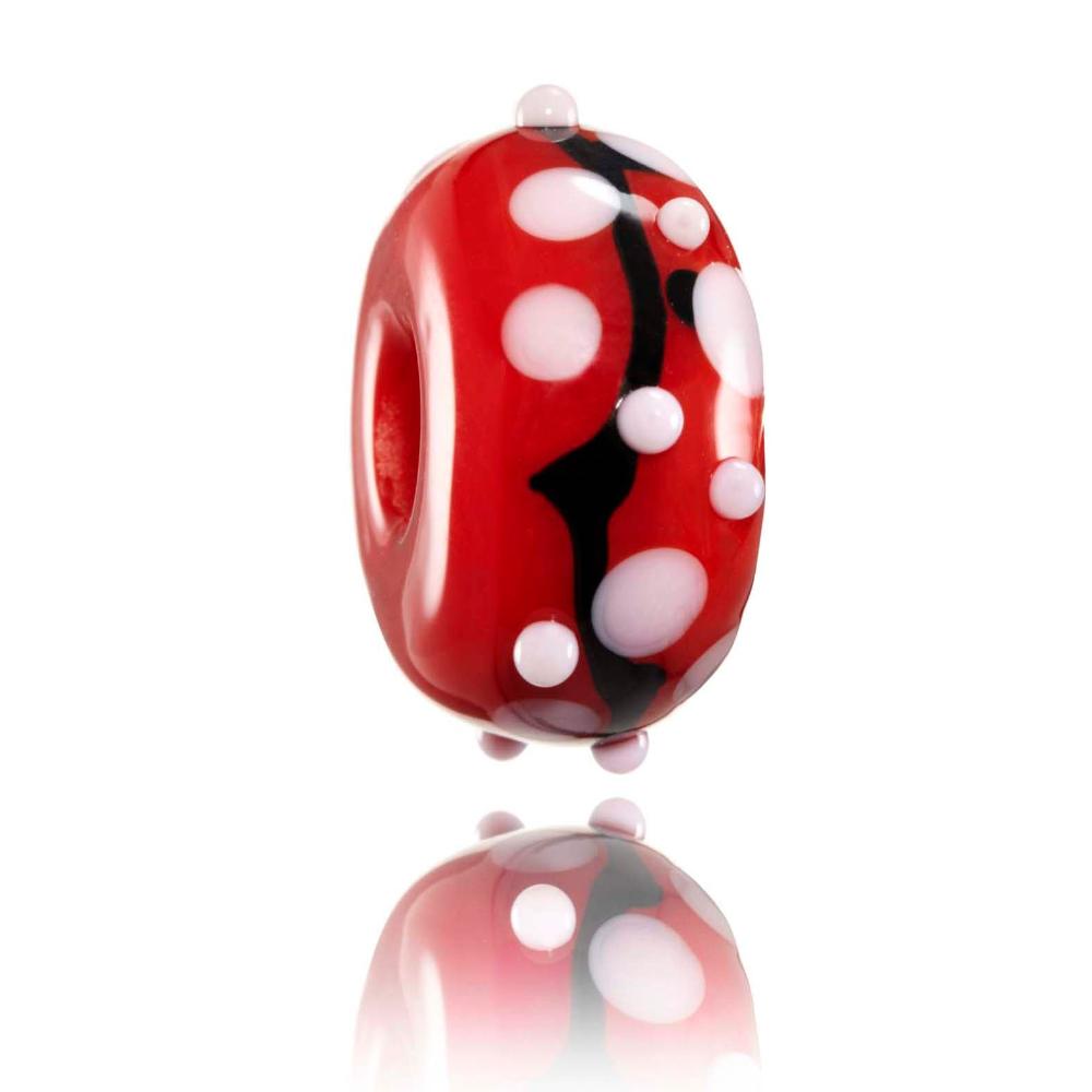 Red glass charm beads with white dots and black stripe patterns representing Japan.