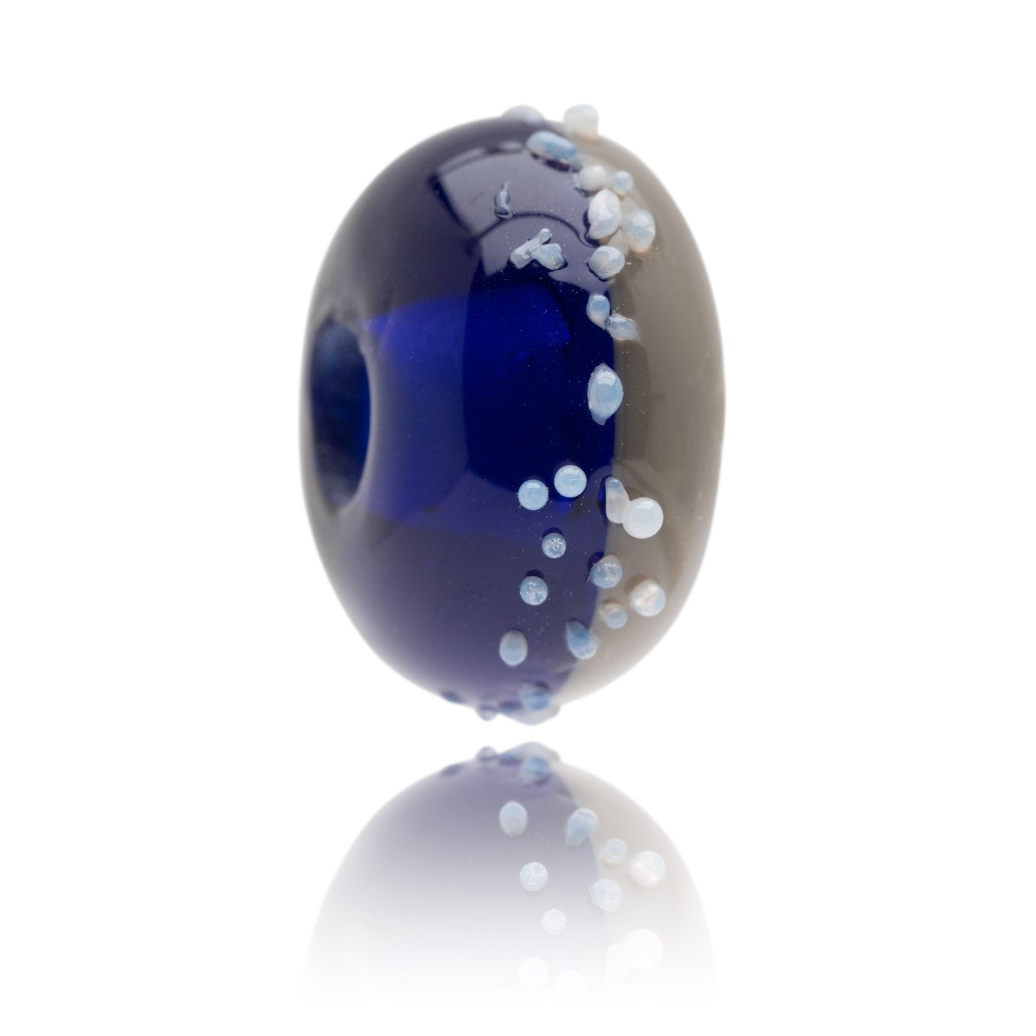 Blue and grey glass bead with white glass speckles on surface for Newgale Beach in Wales.