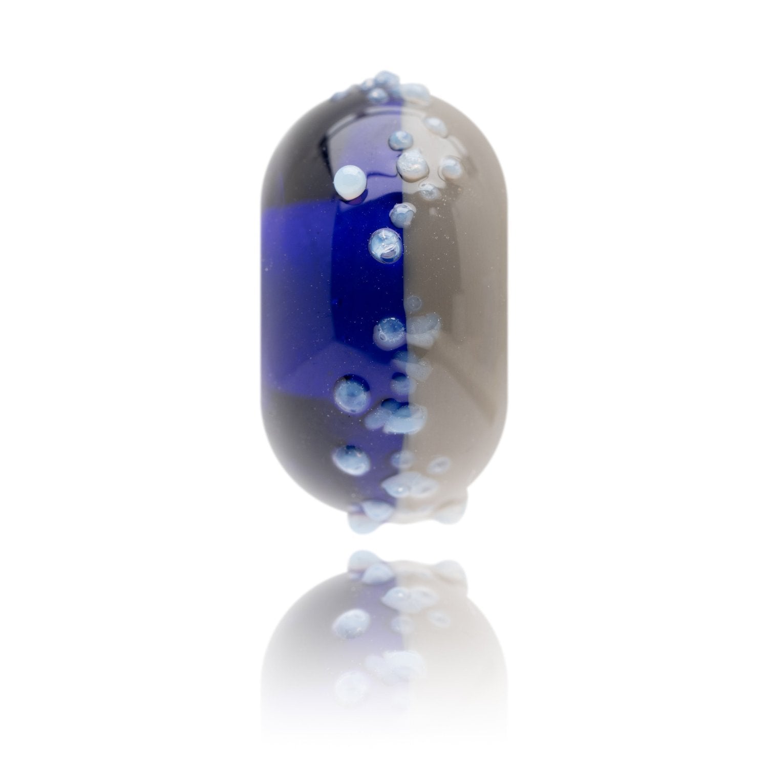 Blue and grey glass bead with white glass speckles on surface for Newgale Beach in Wales.