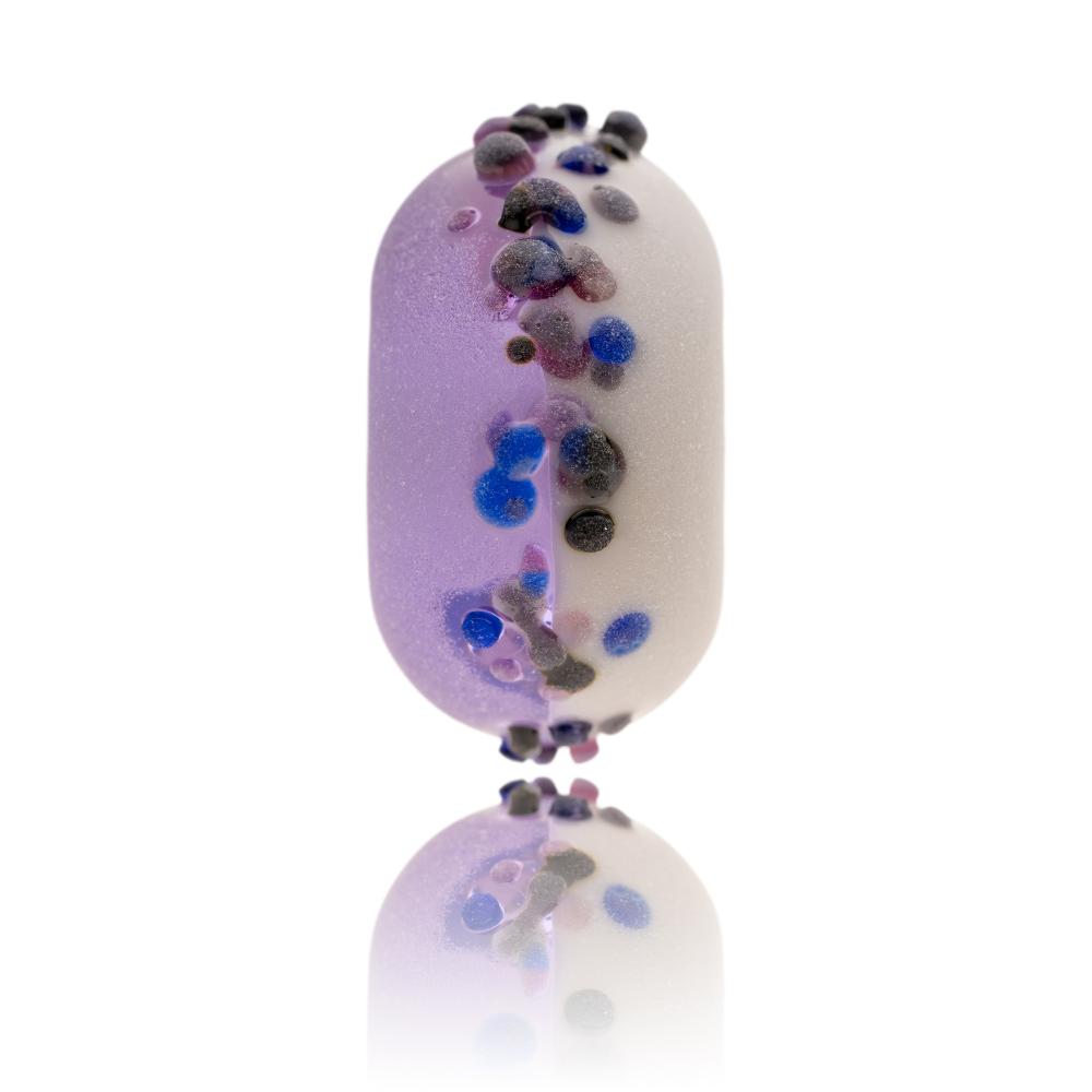 Purple and white glass bead with small blue and purple glass dots on surface for North Uist in Scotland.