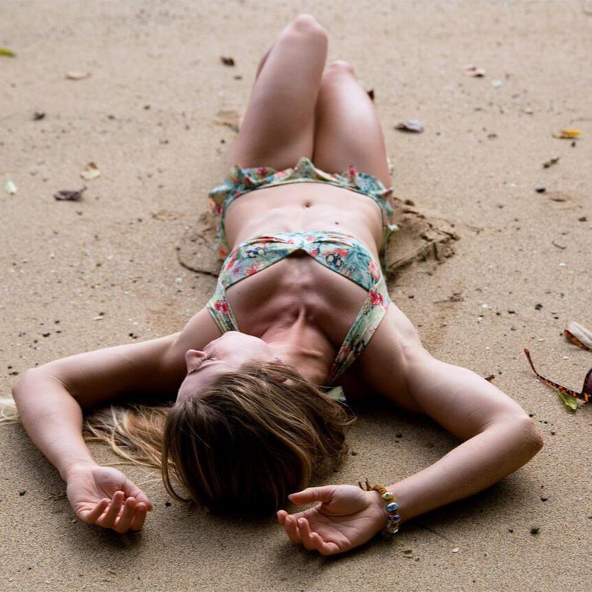 A woman lying on the beach in a bikini.