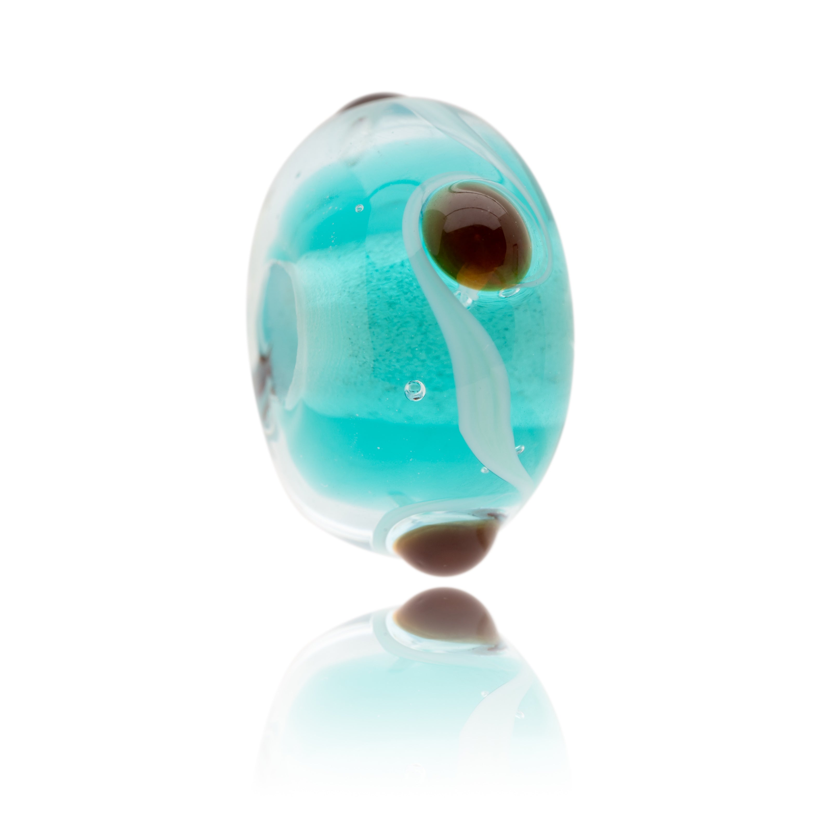 Turquoise and clear Murano glass bead with brown dots, representing Watermouth Cove in North Devon.