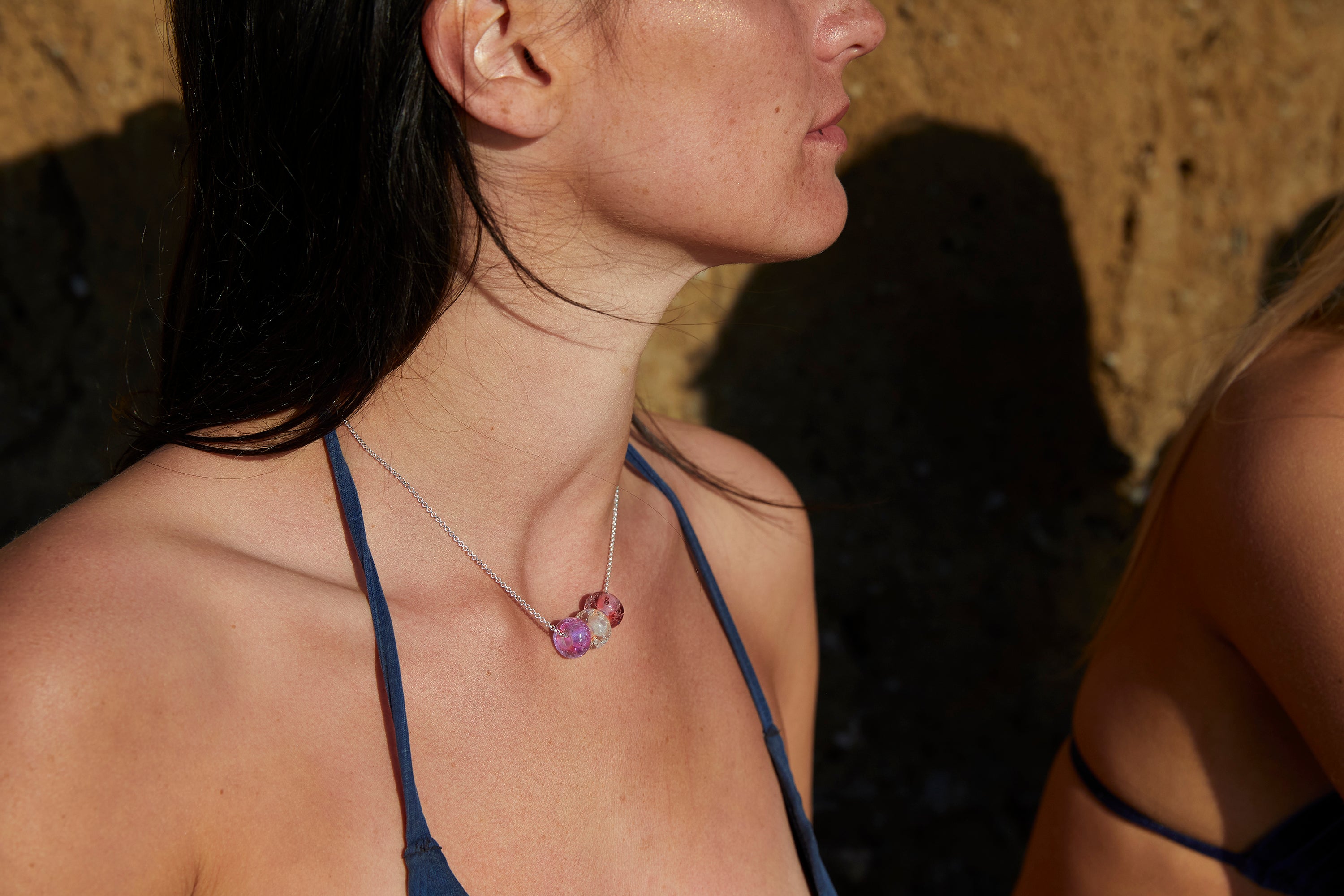 Three pink sand beads worn on silver necklace.