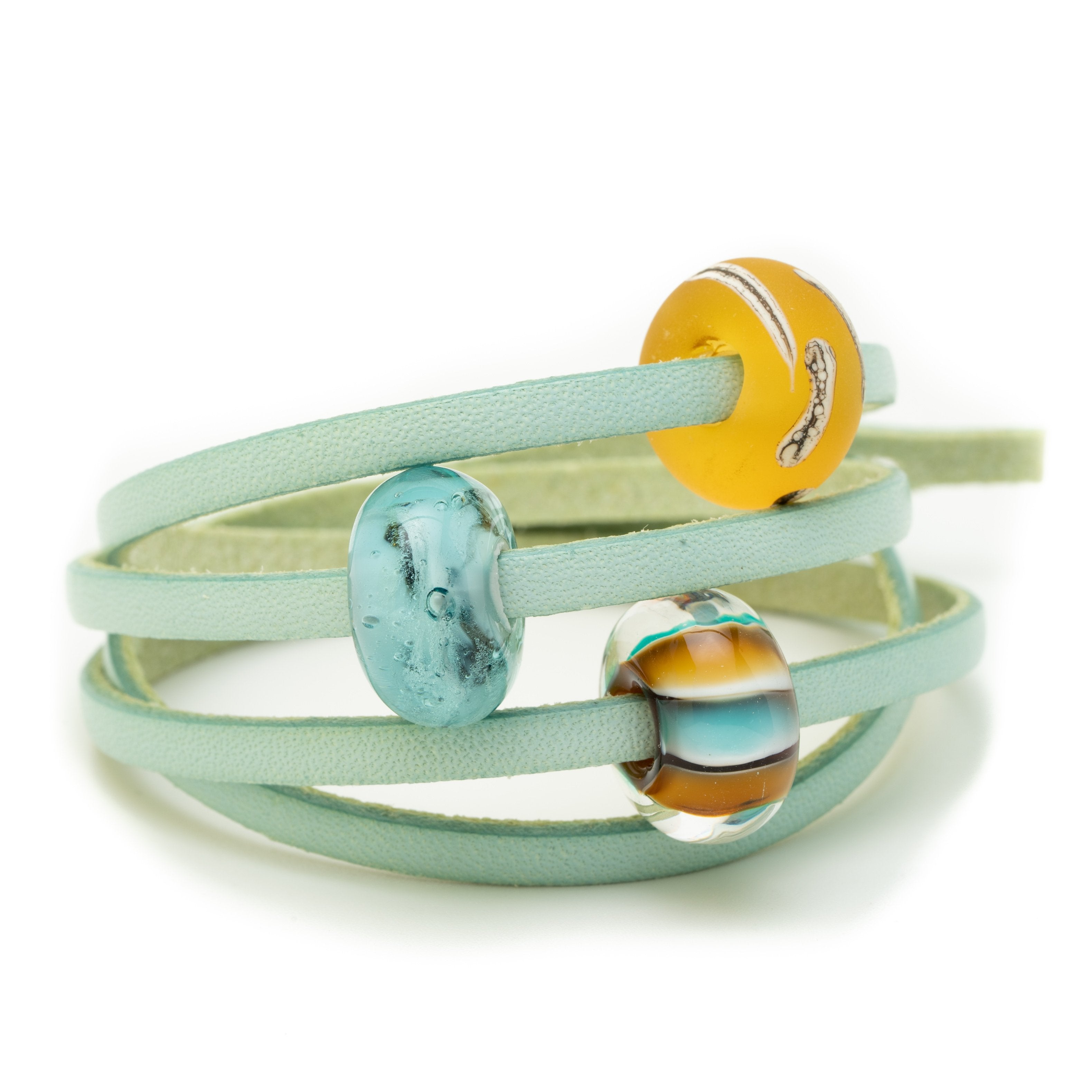 Aqua leather wrap bracelet with amber and blue glass beads representing beach in South Devon, UK.