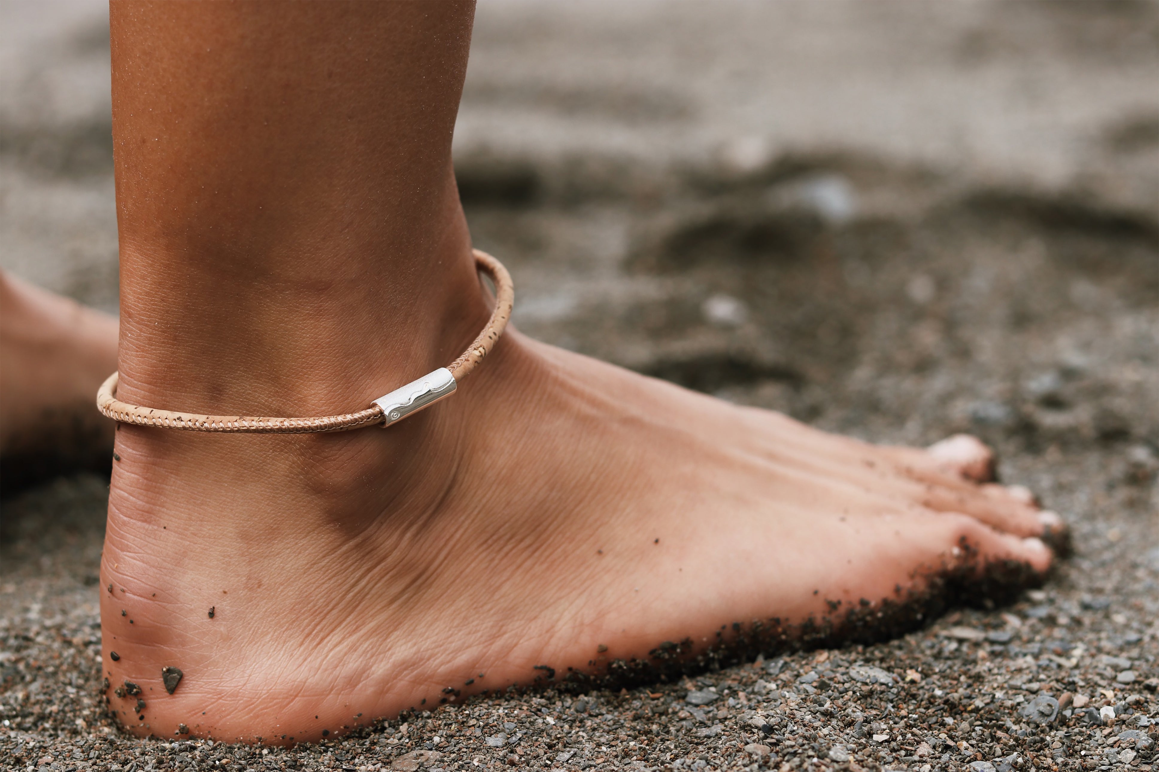 Silver tube coastline bead worn on natural cork anklet.