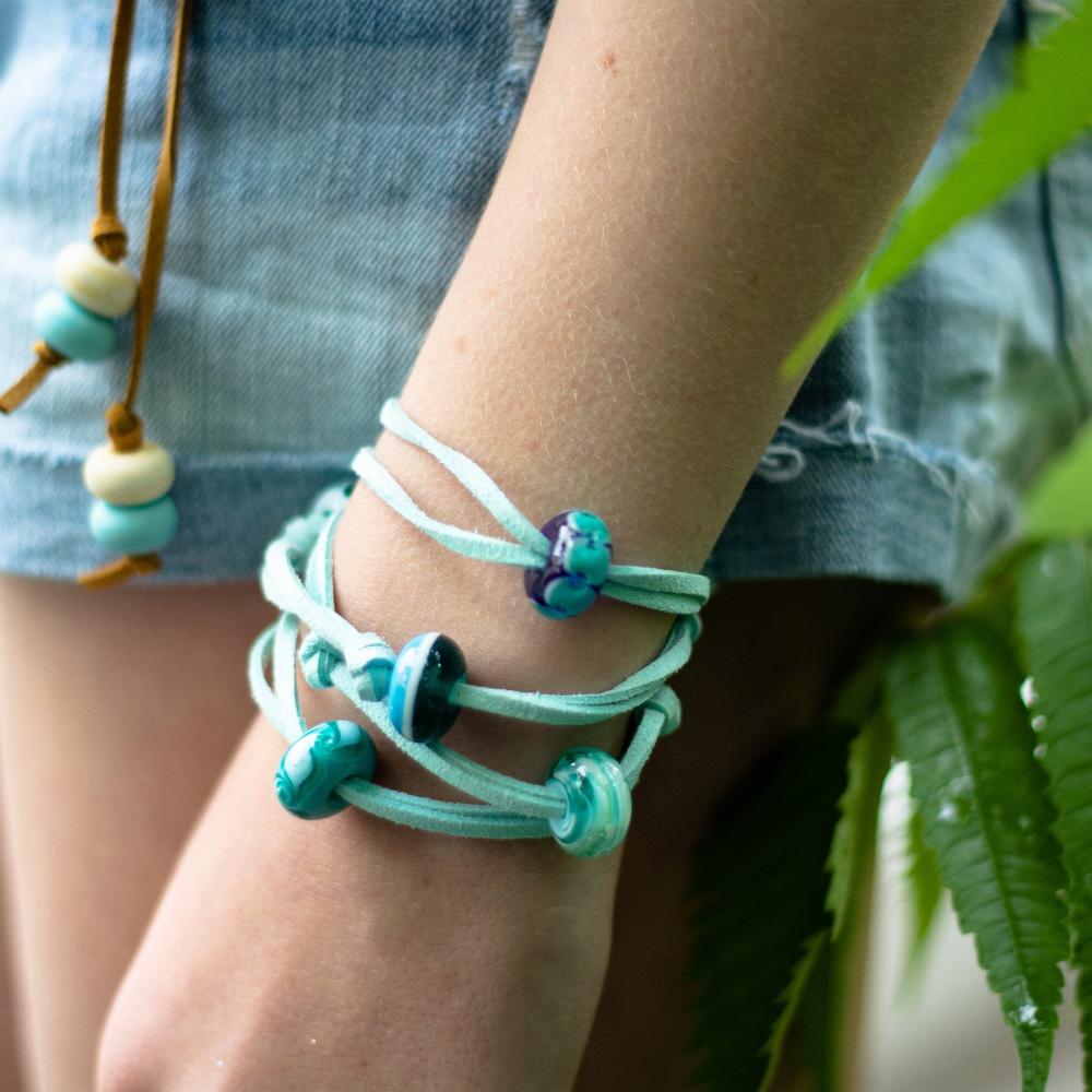 persons wearing int cord bracelet with blue glass beads.