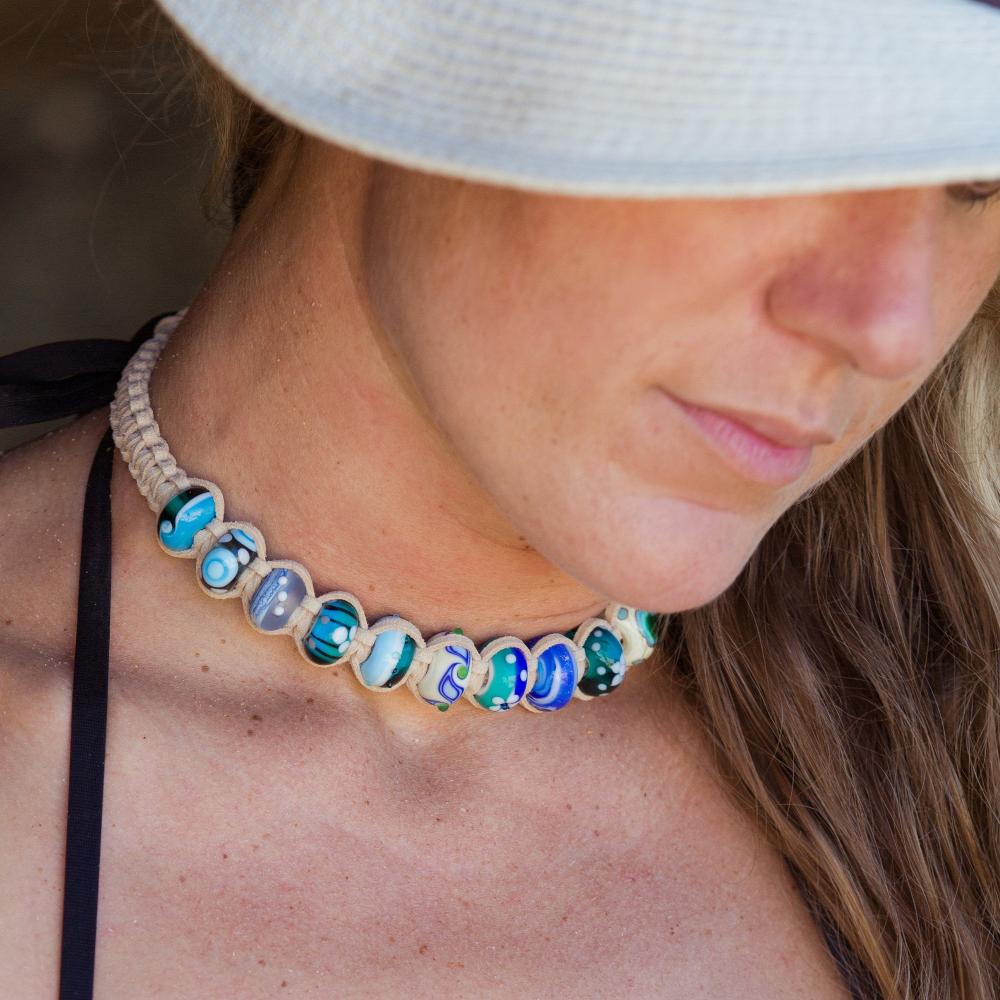 Woman wearing sand cord choker necklace with lots of colorful beads.