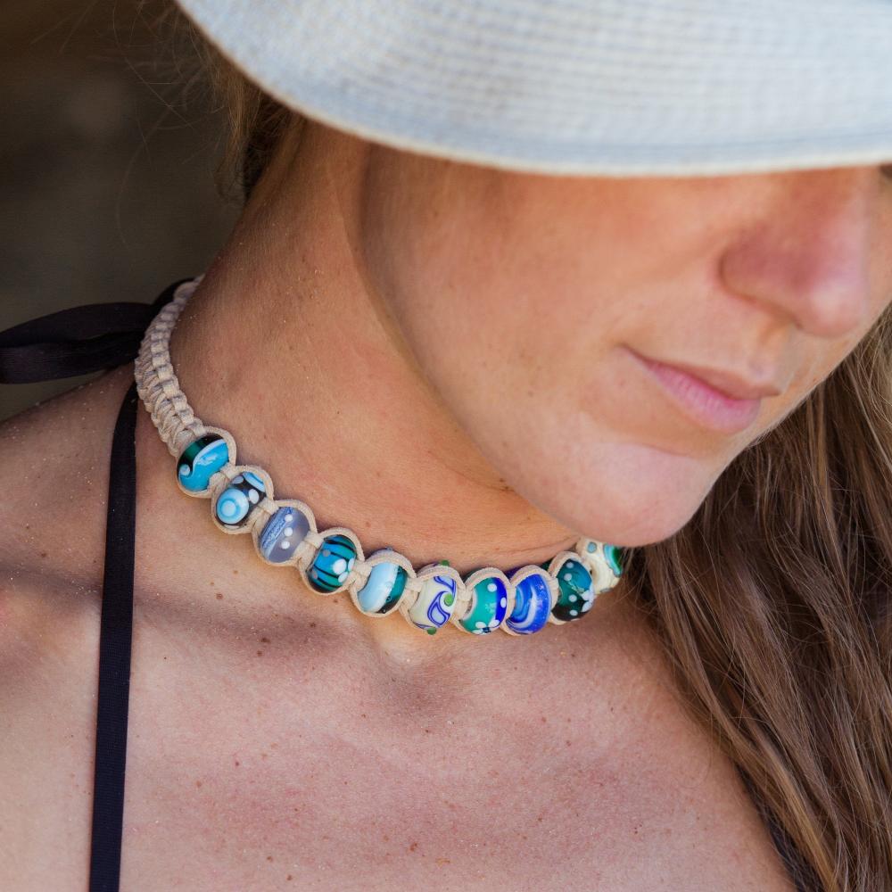 Woman in hat wearing sand cord macrame choker beaded necklace.