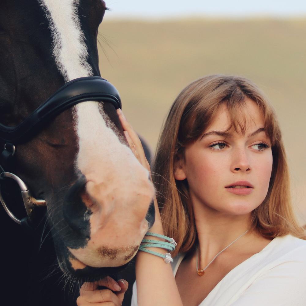 Woman with horse on the beach.