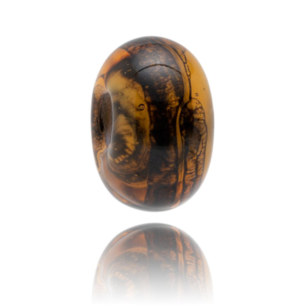 Amber glass bead with black webbing type patterns inside it, representing Lyme Regis own Dorset.