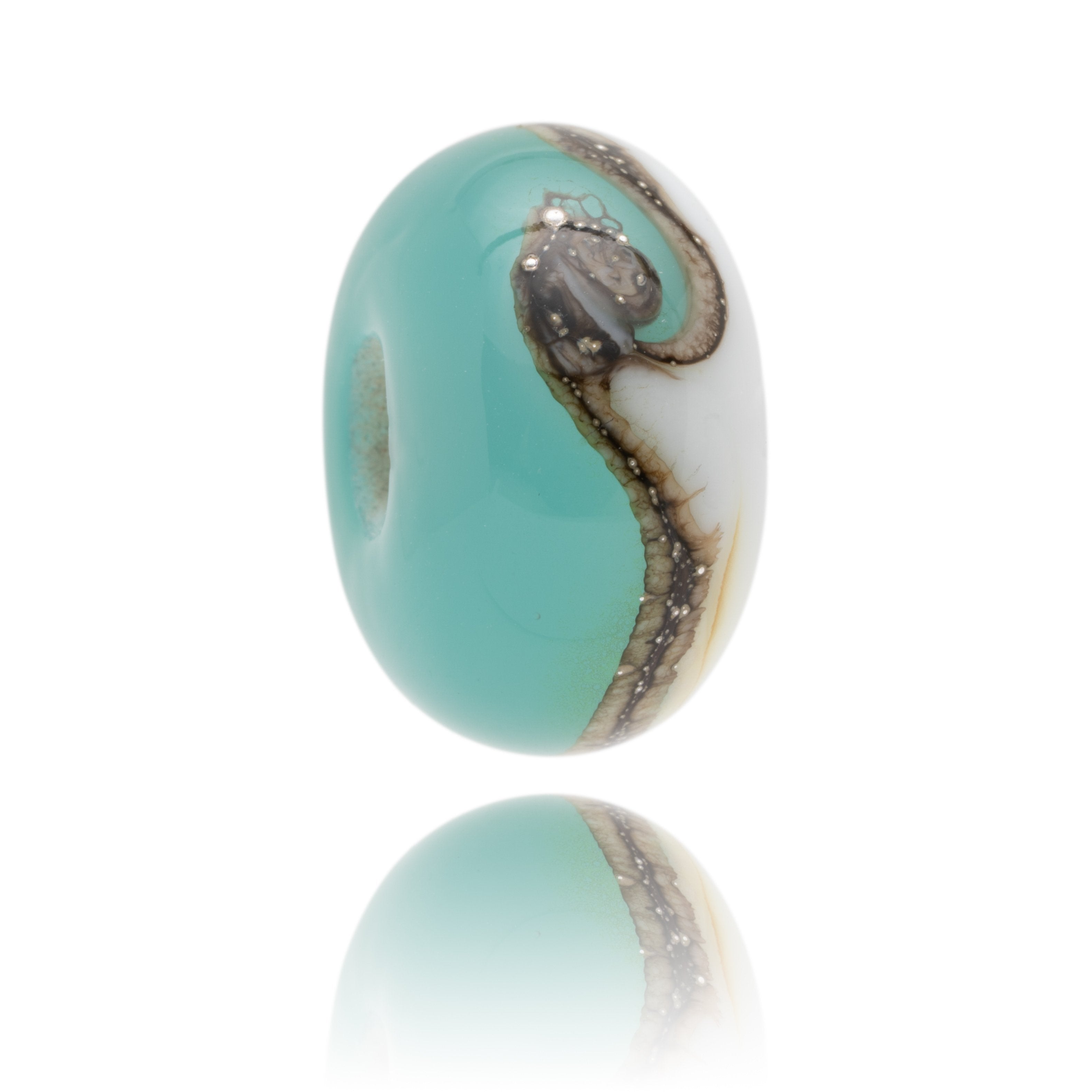 Turquoise glass bead with white one side representing reef break surf spots.