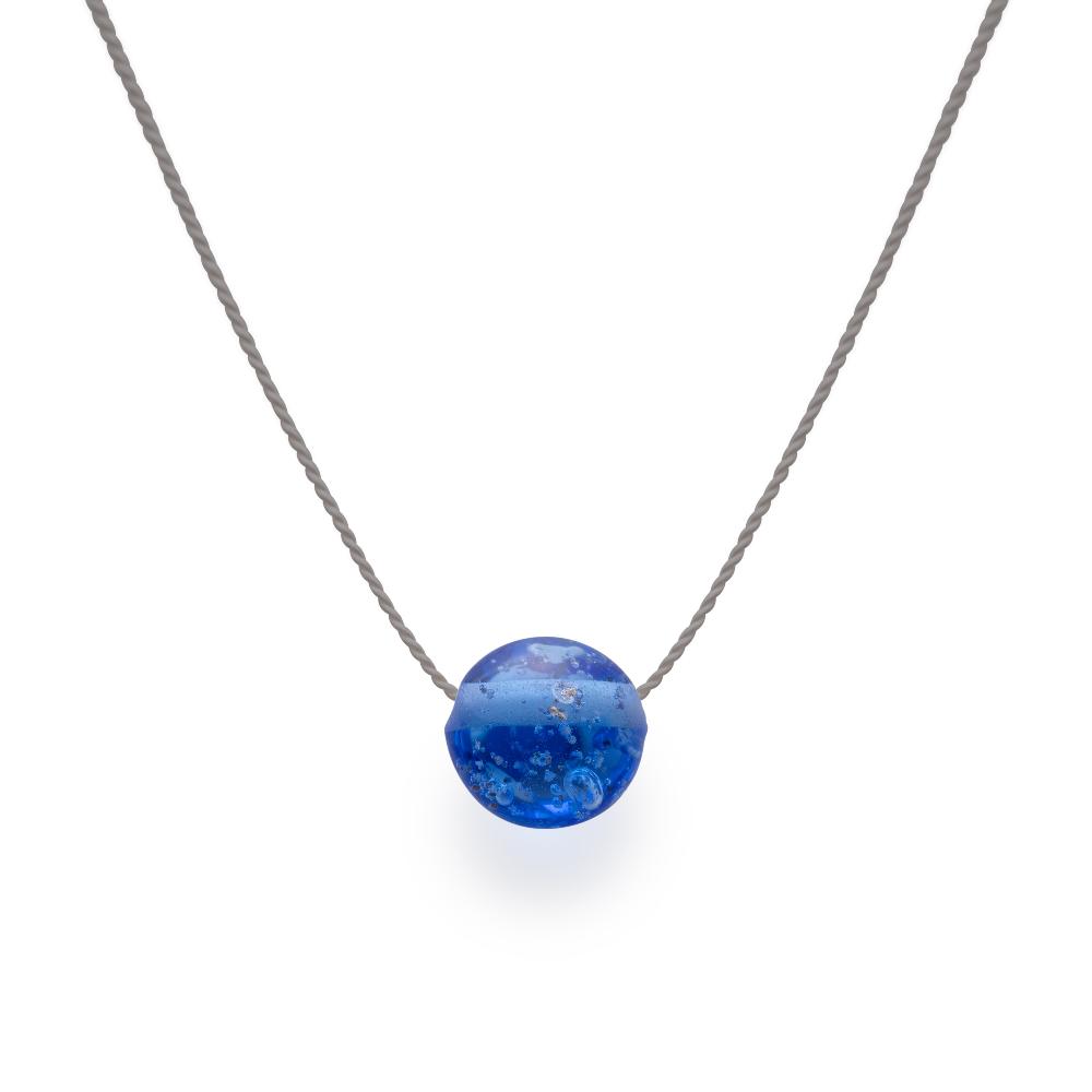 Dark Blue glass bead with grains of sand melted in the glass, strung on a silk cord.