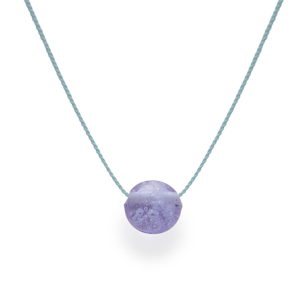 Lavender glass bead with grains of sand melted in the glass, strung on a silk cord.