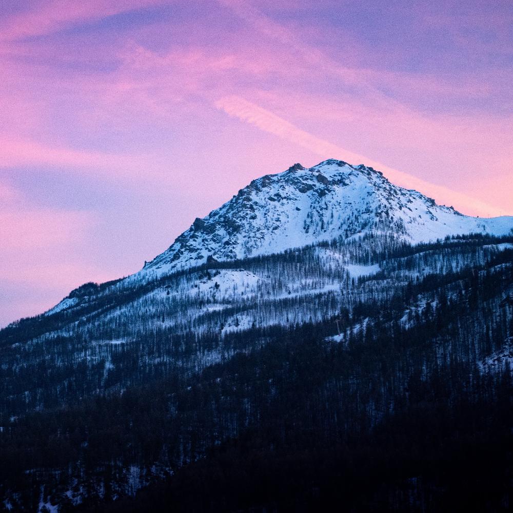 Snow covered mounting against pink skies.