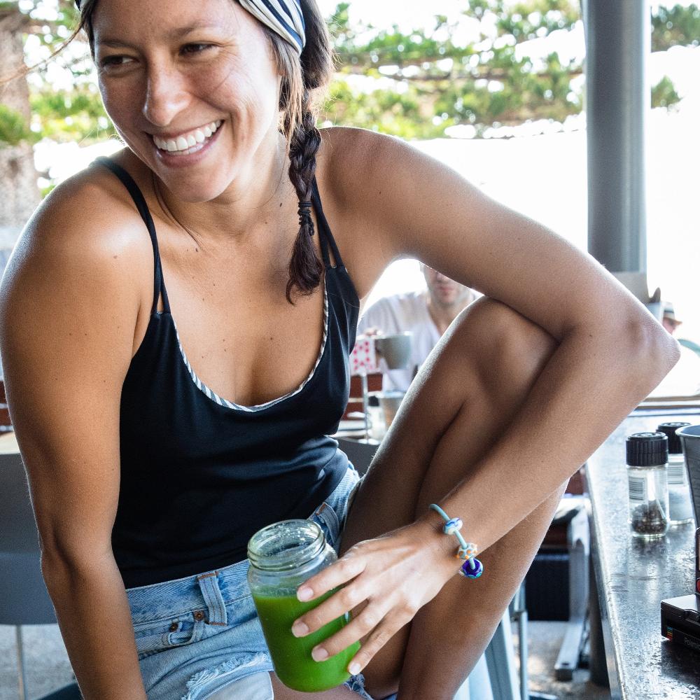 Woman in a Café drinking green juice.