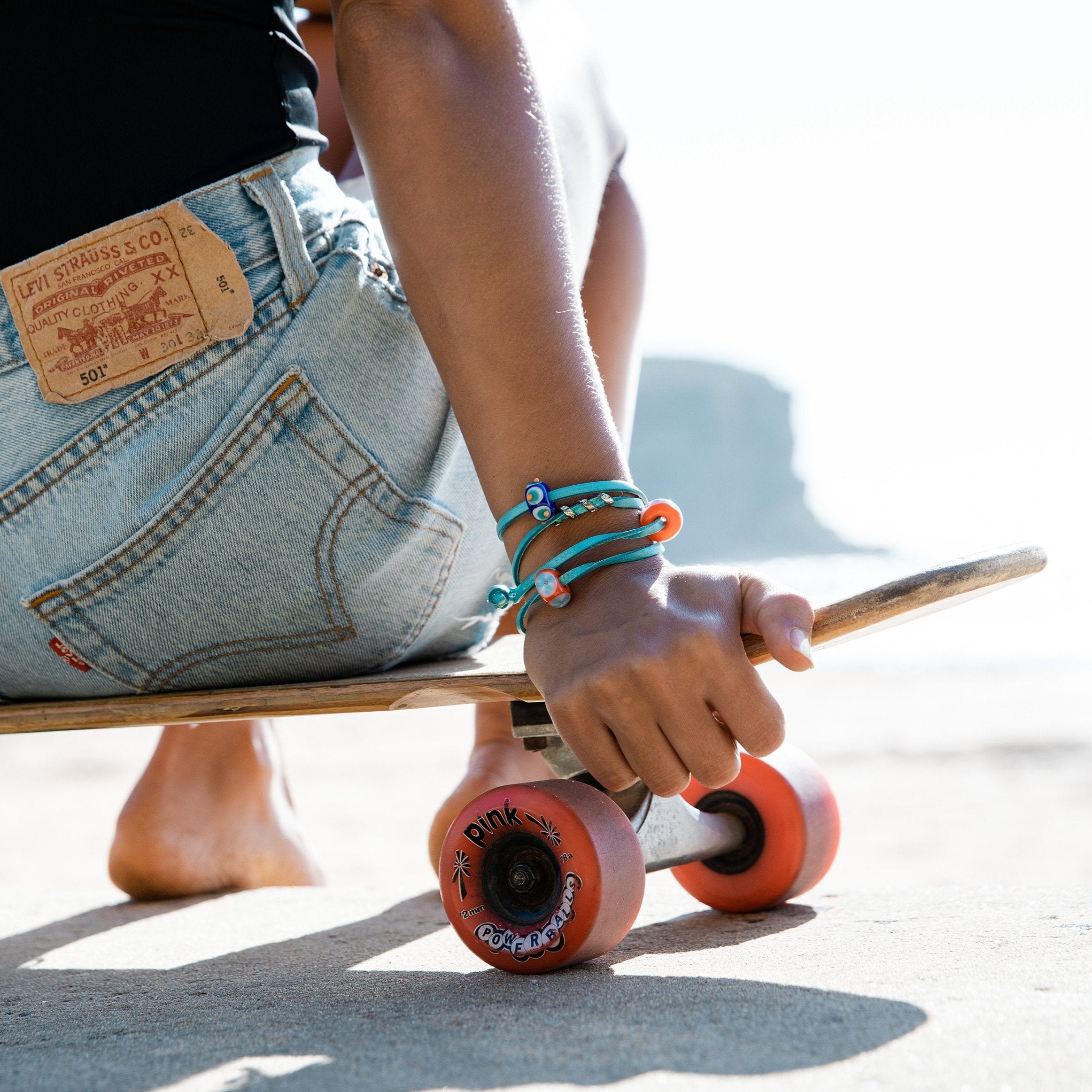 Bright orange and yellow beads representing Australian beaches wiorn on turquoise wrap leather bracelet.